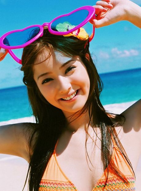 Long haired asian cutie having fun in a striped hot pink bikini