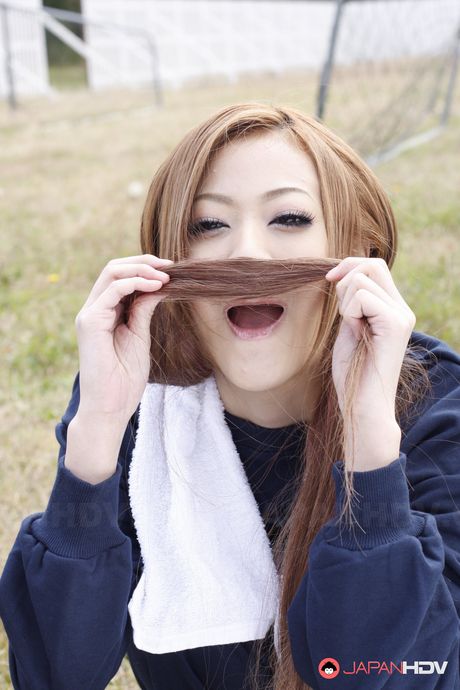 Hot and sensual babe An Umemiya stretches on football field and poses