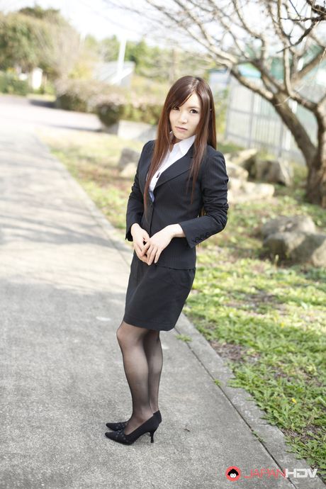 Naughty Hitomi Tsukishiro in office outfit poses so sexy outdoors.